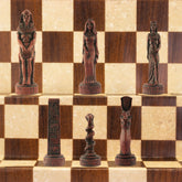 A chess set with pieces featuring ancient Egyptian motifs and figures, placed on a chess board.
This beautiful chess set depicts figures from the civilisation of Ancient Egypt, a society which began around
3150BC, growing rapidly along the  banks of the River Nile. Trade with other countries and its agricultural security helped it to become enormously prosperous; and due to this great wealth the rulers, known as Pharaohs, were very powerful, as were its priests.